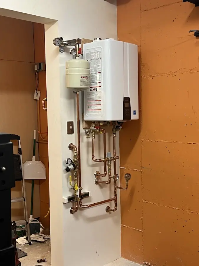 Plumbing technician inspecting water heater connections in Downingtown